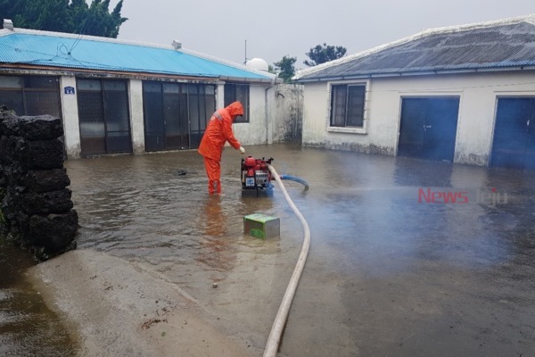 ▲ 주택 침수로 소방 관계자들이 배수펌프를 이용해 물을 빼내고 있다. ©Newsjeju