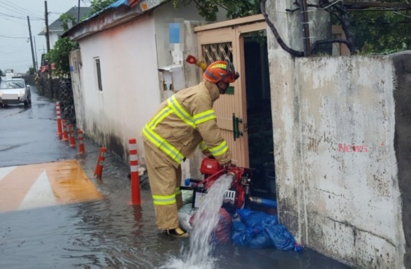 ▲ 주택 침수로 소방 관계자들이 배수펌프를 이용해 물을 빼내고 있다. ©Newsjeju