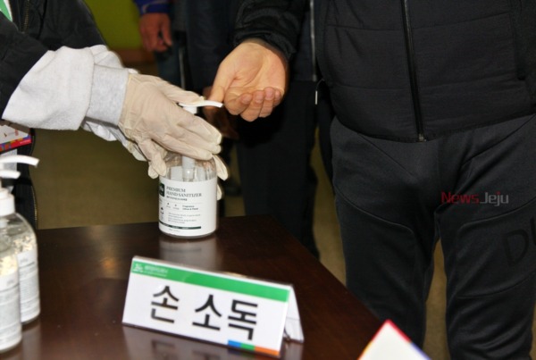▲ 발열 증상이 없는 유권자는 손을 소독한 뒤 비치된 위생장갑을 착용하고 투표사무원에게 신분증을 제시하면 된다. ©Newsjeju
