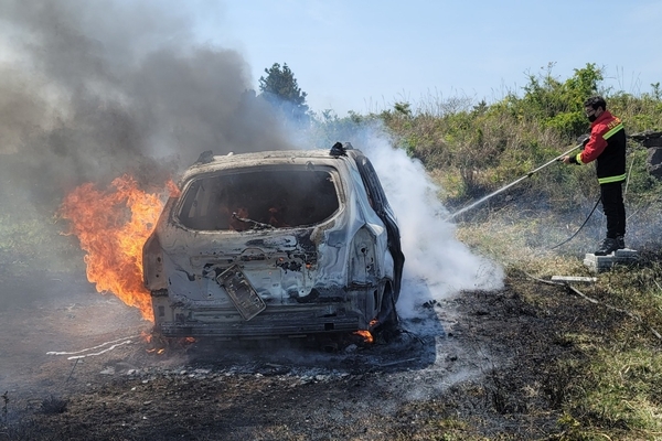 ▲ 산불로 옮겨붙기 전 진화반이 출동해 불에 탄 차량을 진압하고 있다. ©Newsjeju