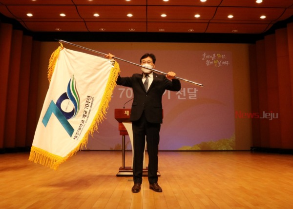 ▲ 송석언 총장이 '개교 70주년 기'를 흔들며 참석자들의 박수에 답례하고 있다. ©Newsjeju