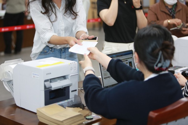 ▲ 연동 지역구 사전투표소(제주도의회 의원회관)에서 투표 용지를 받아들고 있는 유권자. ©Newsjeju